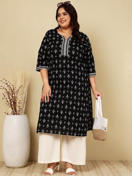 The model is wearing a long, black and white cotton tunic in size 3XL with wide-legged white summer trousers.